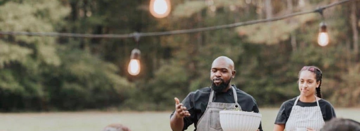 A chef presenting a course at an outdoor chef-led dinner